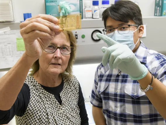 Dr. Anne Cress with Elijah Keeswood looking at slide.