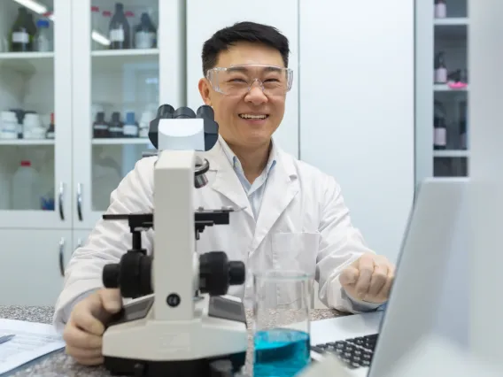 Lab worker at desk with microscope