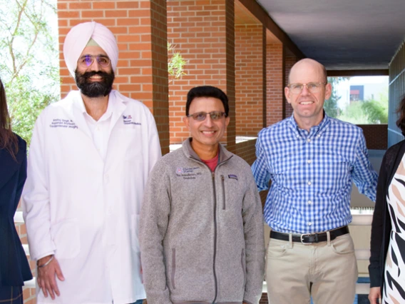 A diverse group of doctors and nurses standing together, showcasing teamwork and dedication in a healthcare setting.