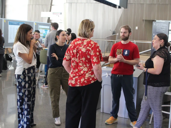 [Two residents speak with IM Residency – Tucson program manager Mary Gosciminski (center in red top), admin Yuvia Anaya (left) and former coordinator Monica Jimenez (right).]