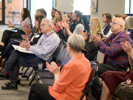 [Applauding from the audience from the DOM, see (from right in second row) the Pulmonary division’s James Knepler, MD, incoming 2025-26 LAMS Fellow Jennifer Plitt, MD, a palliative medicine specialist in the GGP division, and GGP’s Kris Abbate, MD, whose wife Michelle was a 2024-25 LAMS Fellowship graduate.]