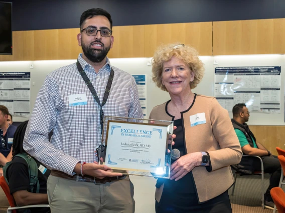 [Joshua Sethi, MD, MS, who won an Excellence in Research Award at the SOAR in the DOM forum, with Janet Funk, MD, DOM vice chair for research.]