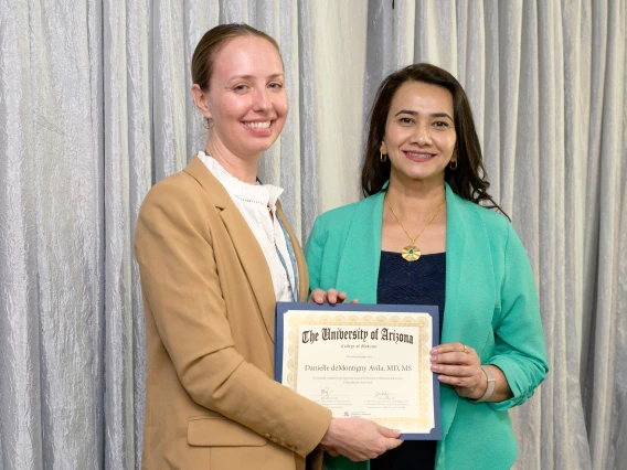 [The Infectious Diseases division’s Danielle Avila, MD, accepts her LAMS graduation certificate from COM-T Assistant Dean Hina Arif, MD.]