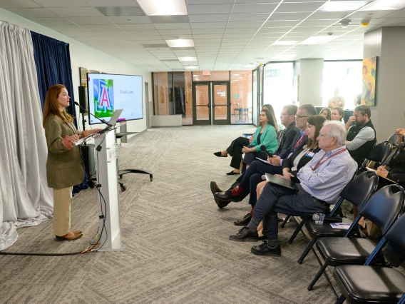 [The audience at the LAMS Fellowship graduation event in the COM-T Social Hall listen raptly to DOM Interventional Pulmonology director Billie Bixby, MD, presenting on her Leadership Experience Project.]