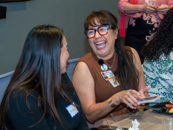 [Jacque Carrillo and Brenda Lambert, admins and fellowship coordinators in the Division of Pulmonary, Allergy, Critical Care & Sleep Medicine, share a laugh during the 2025 DOM Administrative Professionals Day breakfast]