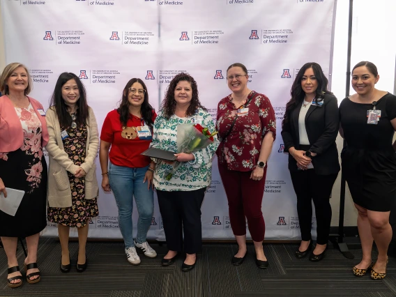 [Gina Favela (center with flowers), winner of the Employee Choice Award, with (from left) Cynthia Campas, Phetcharat “Pat” Chen, Endocrionology’s Melody Ayon, Cardiology’s Christeana Castro, Dominica Padilla, and Nephrology’s Bersabe Lopez. Lopez and Castro also are lead admins for the DOM Vice Chair of Education Office.]