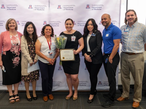 [Bersabe Lopez (center with flowers), winner of the Department Staff MVP award, with (from left) Cynthia Campas, Phetcharat “Pat” Chen, Gastroenterology’s Maria Longoria, Dominica Padilla, and clinical associate directors Scott Hall and Jason Toone.]