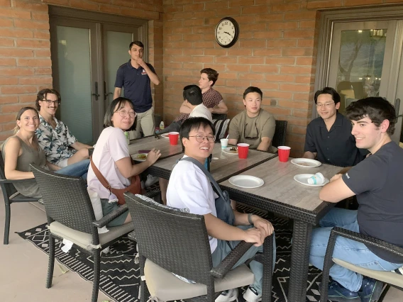 [After the Mount Lemmon trek, hikers relax in the shade back in Tucson, including (from left) Adrianna Diviero, MD,  her friend, Andres Sanchez, MD (standing), (unidentified - back of head to camera), Benjamin Maglajac, MD, (unidentified), Hyun Kim, MD, Chris Sallurday, DO, and (in the foreground, center) Justin Le, MD, and Laura Tran, MD, with lunch and cold beverages.]