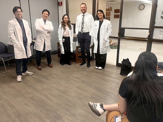[In their white coats (from left), new Internal Medicine interns Tim Yu, MD, Shawn Wang, MD, Nellie Tolliver, MD, Cooper Stateler, MD, and Sheyda Mesgarzadeh, MD, wait their turn for profile photos to be shot at the UAHS BioCommunications photography studio on the College of Medicine – Tucson’s third floor.]