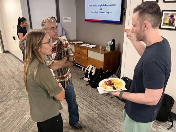 [Eric Brucks, MD, a Tucson VA Medical Center physician who’s an associate program director for IM Residency – Tucson program members training there, chats with new intern Nicole Price, MD, and fellow IM Residency associate program director J.P. Ferreira, MD.]