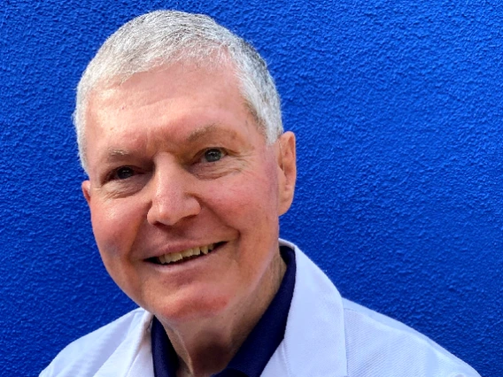 Dr. Hector in front of a blue wall