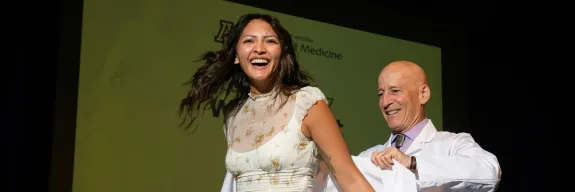 female student accepting her white coat