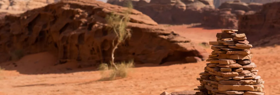 Photo of desert landscape with rocks purposefully stacked