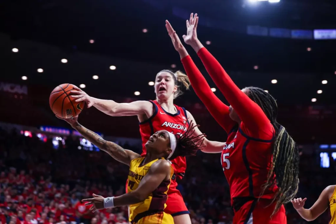 U of A’s Mailen Rolf (#13) and Breya Cunningham (#25) block the shot of an ASU player at the Feb. 8, 2025 Wear Red for Heart Health game at McKale Center.
