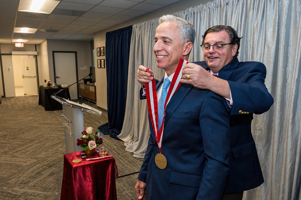 College of Medicine – Tucson Dean Michael Abecassis, MD, MBA, places the investiture medallion on Hesham Sadek, MD, PhD, Cardiology division chief and Sarver Heart Center director.
