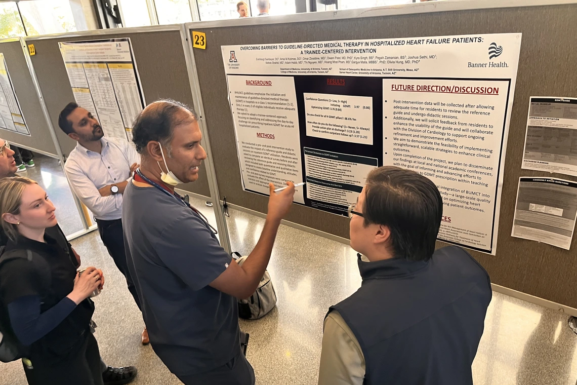 [Rajesh Kotagiri, MD, an Inpatient Medicine hospitalist and associate professor, asks questions of Enkhtsogt Sainbayar, DO, a PGY-2 IM resident, about his poster on “Overcoming Barriers to Guideline-Directed Medical Therapy in Hospitalized Heart Failure Patients: A Trainee-Centered Intervention.”]
