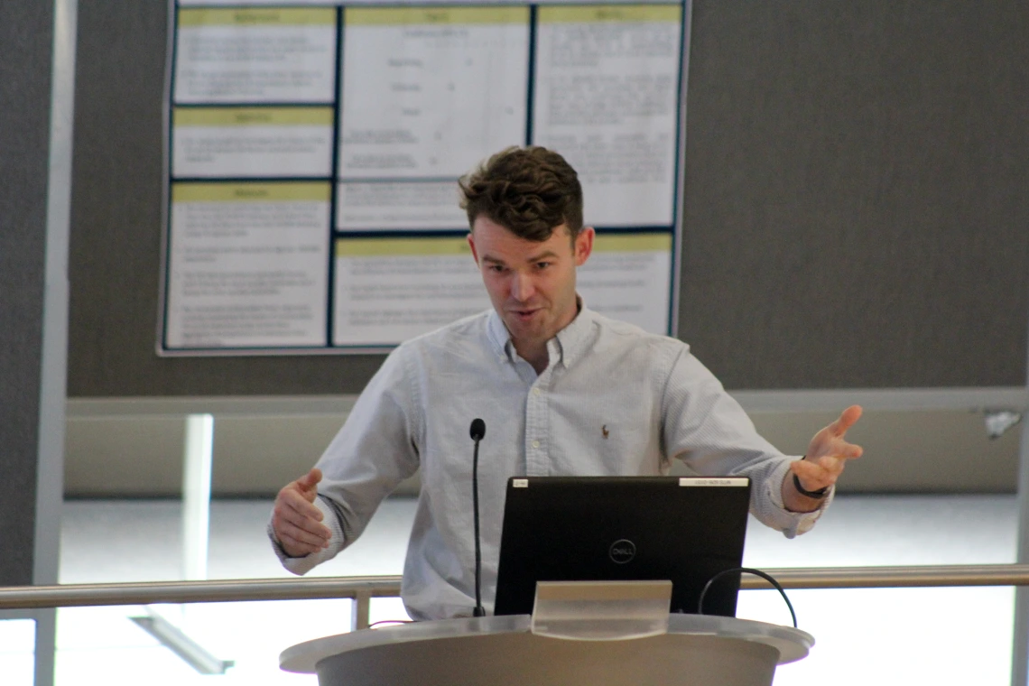 [PGY-2 Nathan Walton, MD, gestures as he talks about his research project, “Surety of Parasitosis: A curious case of Wohlfahrtiimonas Bacteremia,” during oral presentations.]