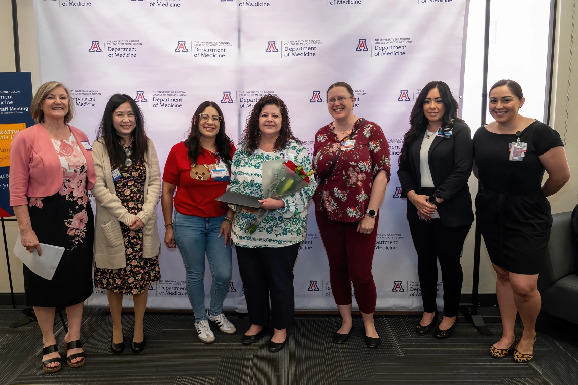 [Gina Favela (center with flowers), winner of the Employee Choice Award, with (from left) Cynthia Campas, Phetcharat “Pat” Chen, Endocrionology’s Melody Ayon, Cardiology’s Christeana Castro, Dominica Padilla, and Nephrology’s Bersabe Lopez. Lopez and Castro also are lead admins for the DOM Vice Chair of Education Office.]