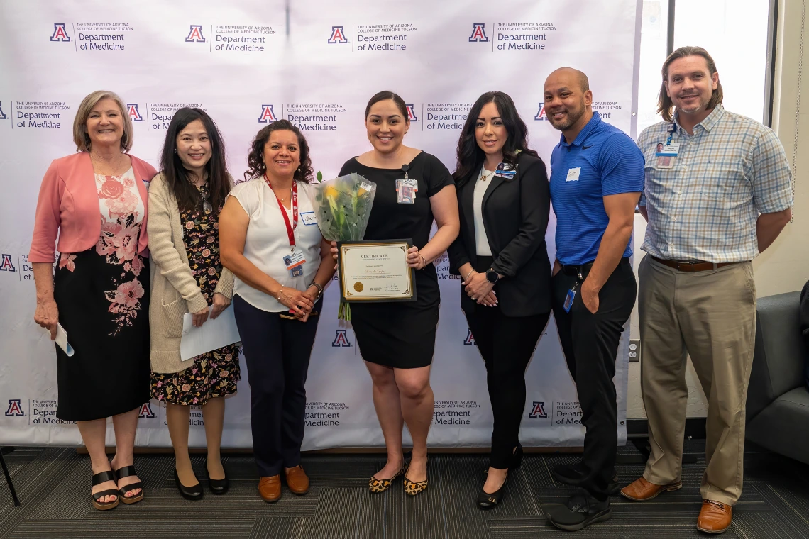 [Bersabe Lopez (center with flowers), winner of the Department Staff MVP award, with (from left) Cynthia Campas, Phetcharat “Pat” Chen, Gastroenterology’s Maria Longoria, Dominica Padilla, and clinical associate directors Scott Hall and Jason Toone.]
