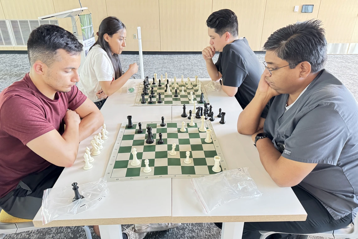 [Pondering a plan of attack or defense: Asael Nuñez, MD (PGY-2 IM resident – in maroon top), Inpatient Medicine’s Anil Potharaju, MD, and Nathan Holt, DO (PGY-1 radiology resident – in black top), and his wife.]