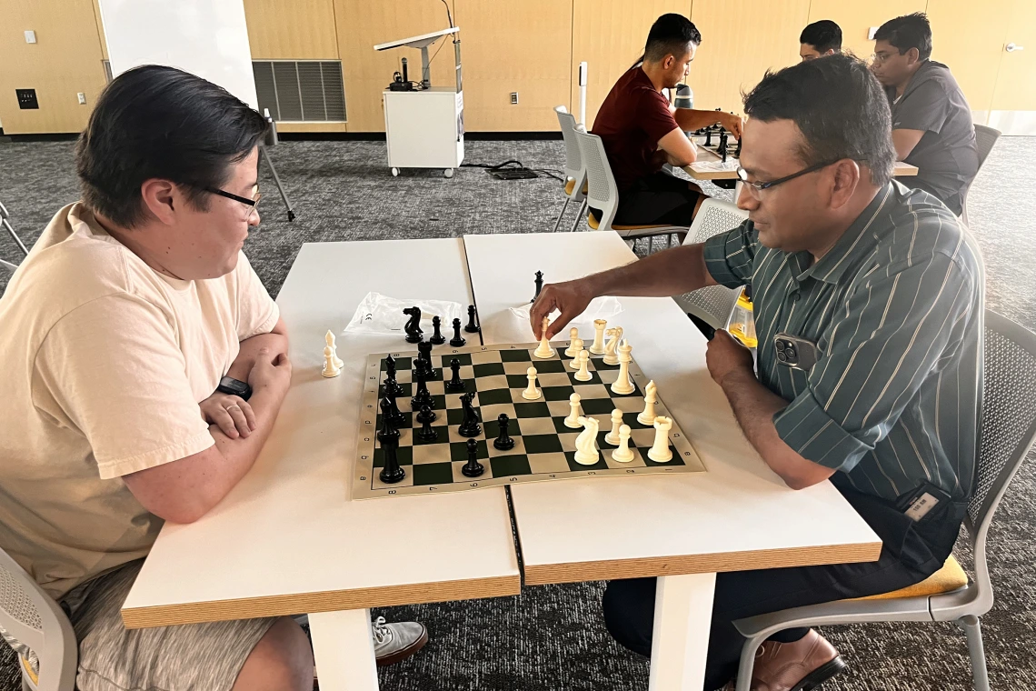 [J’adoube: Nephrology’s Bijin Thajudeen, MD, with hand on his queen, looks for the best place to place her, as Steve Sainbayar, DO (PGY-3 IM resident) strategizes a follow-up move.]