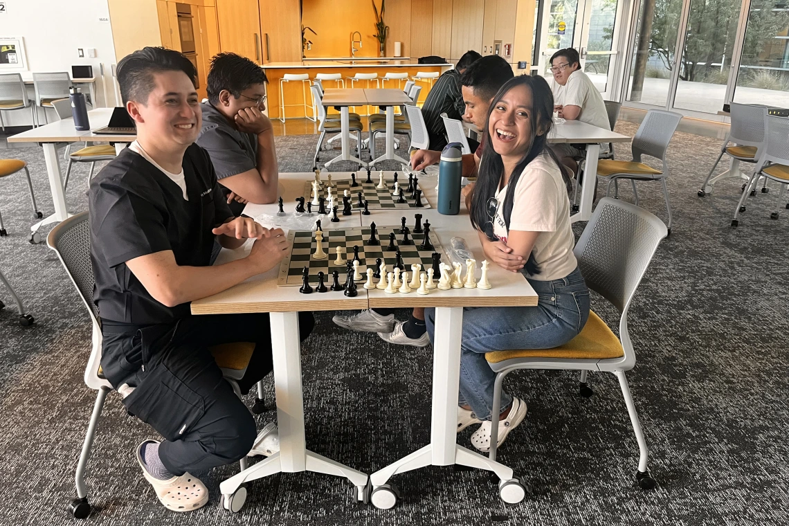 [Nathan Holt, DO (PGY-1 radiology resident – in black top), and his wife laugh about the turn of events in their chess match.]