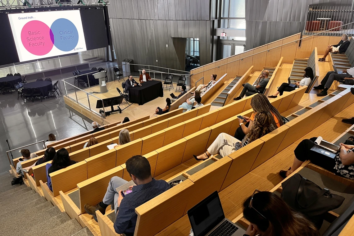 [CTDW co-leaders Jarrod Mosier, MD, and Franz Rischard, DO (seated at table onstage), discuss the practicalities intertwined between clinical faculty and basic science faculty – and the collaborative nature of how that fits into the academic setting at the University of Arizona.]