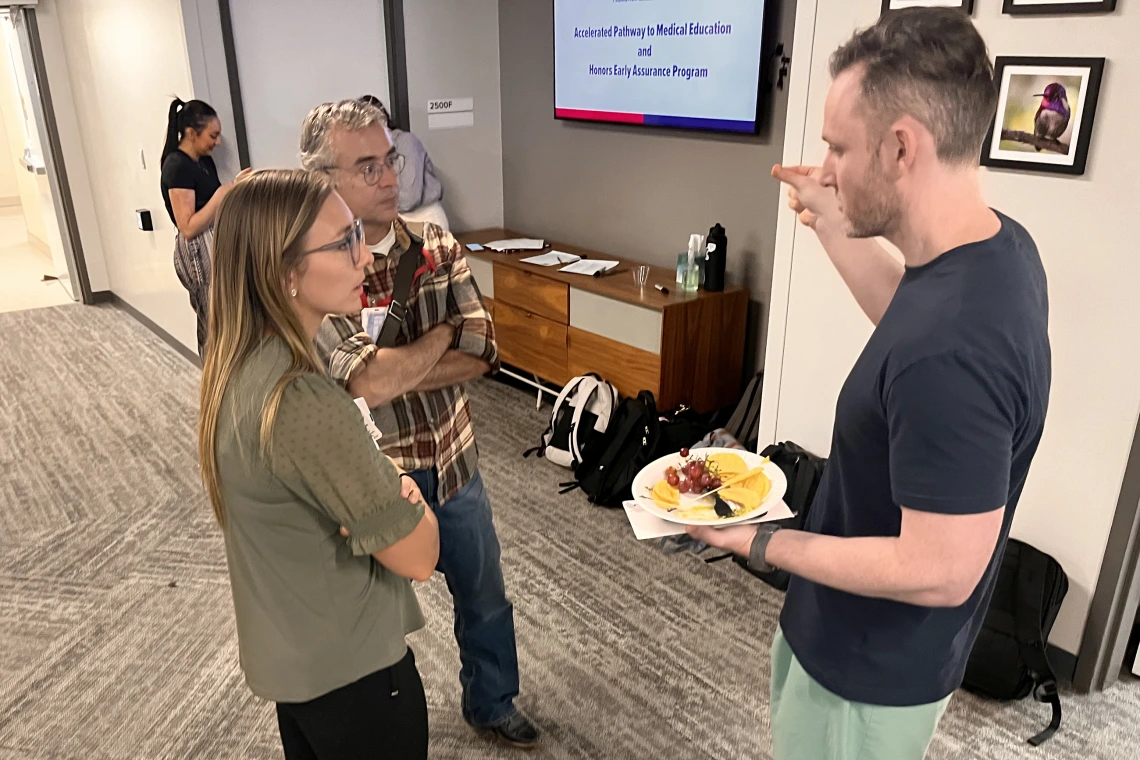 [Eric Brucks, MD, a Tucson VA Medical Center physician who’s an associate program director for IM Residency – Tucson program members training there, chats with new intern Nicole Price, MD, and fellow IM Residency associate program director J.P. Ferreira, MD.]