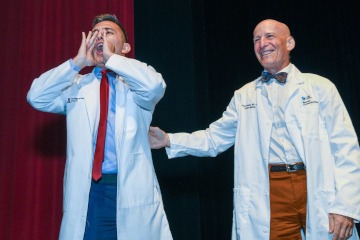 A member of the College of Medicine - Tucson Class of 2026 receives his white coat.
