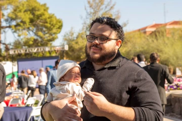 Curtis McGuire holds his 3-month-old son Kai after learning his family will stay in Tucson as he completes his residency in anesthesiology.